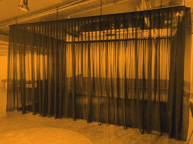 Black sheer voile hung as a room divider