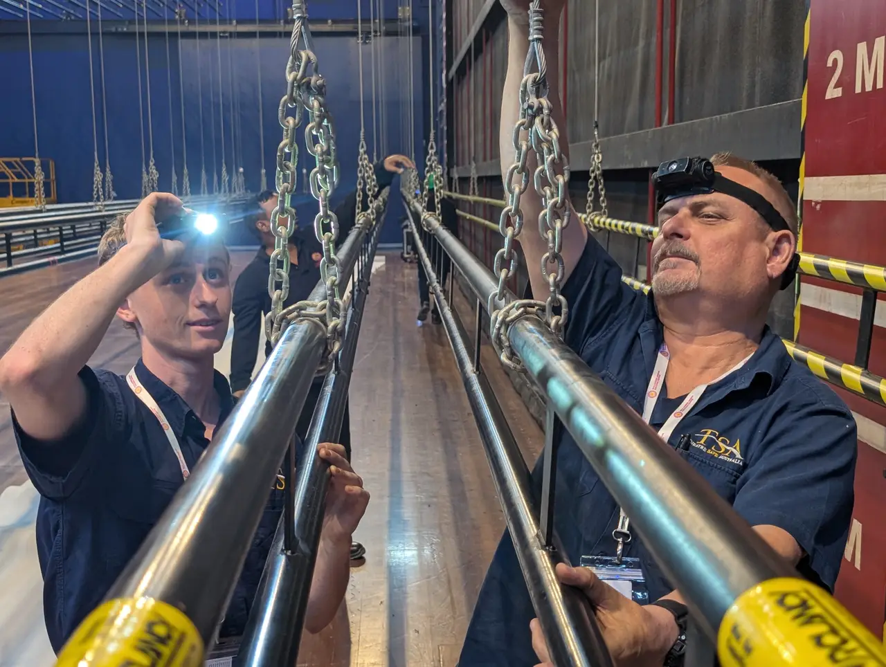 TSA crew inspecting chain terminations on stage battens