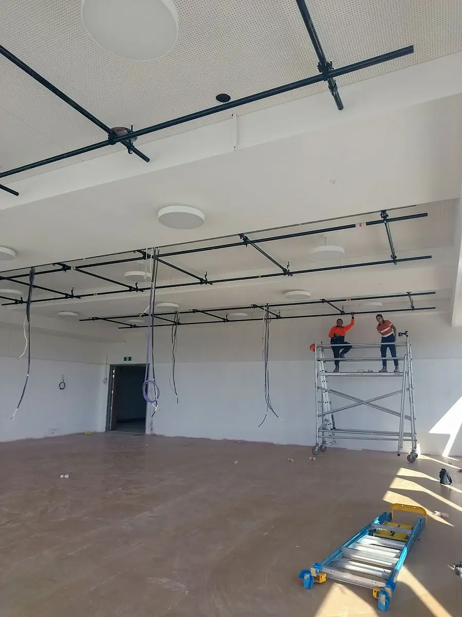 Overhead services and rigging grid being installed from an elevated platform